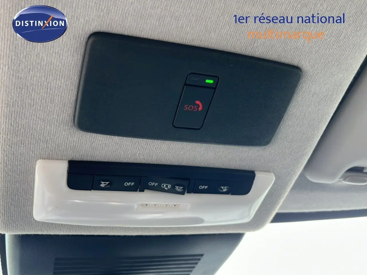 Vue en gros plan du plafonnier intérieur avec bouton SOS allumé sur Nissan Juke noir métal 2023.