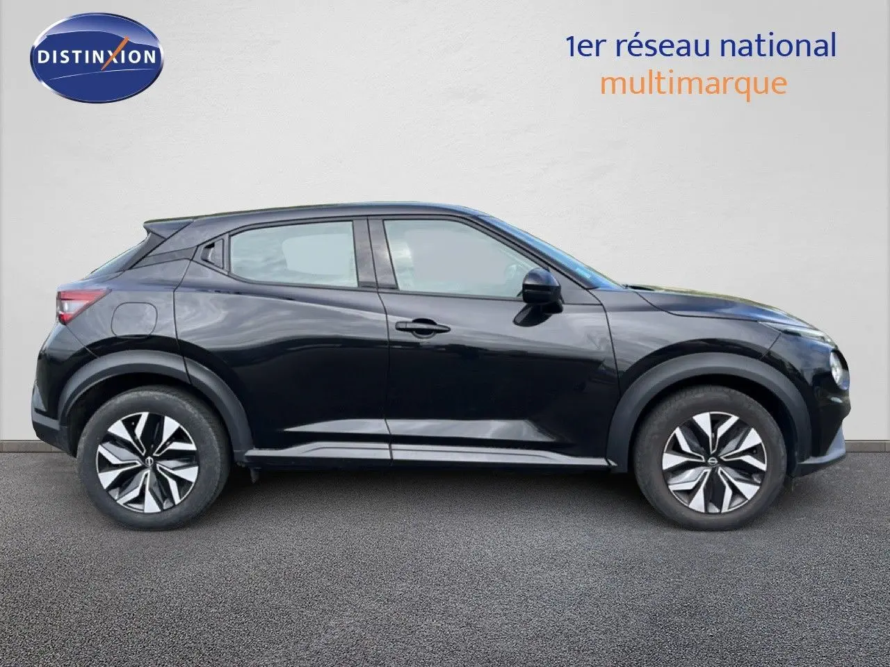 Profil droit d'un Nissan Juke noir métal 2023, avec jantes distinctives et lignes dynamiques visibles.