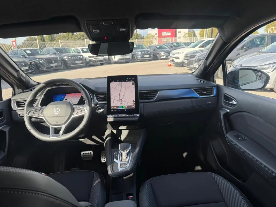 Vue intérieure avant du Renault SYMBIOZ gris clair 2025, avec tableau de bord moderne et écran tactile vertical.