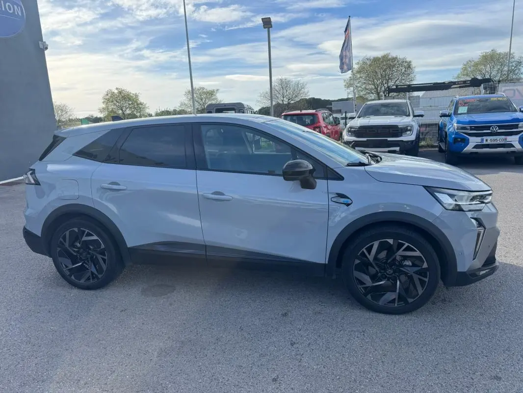 Profil droit d’un Renault SYMBIOZ gris clair avec jantes alliage noires de 19 pouces, garé en extérieur.