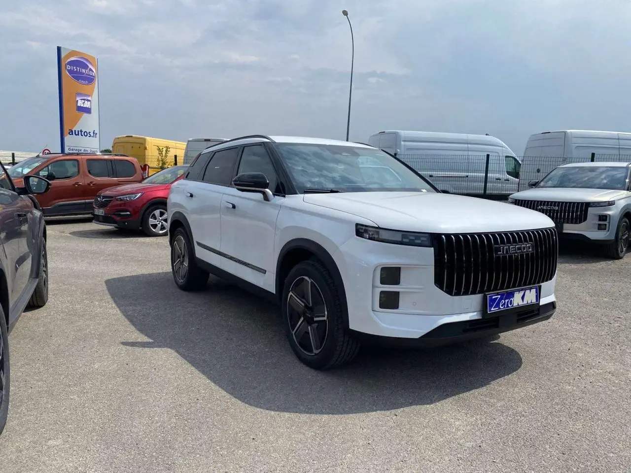 SUV JAECOO J7 blanc khaki vu en 3/4 avant droit avec calandre verticale noire et jantes alliage 19 pouces.