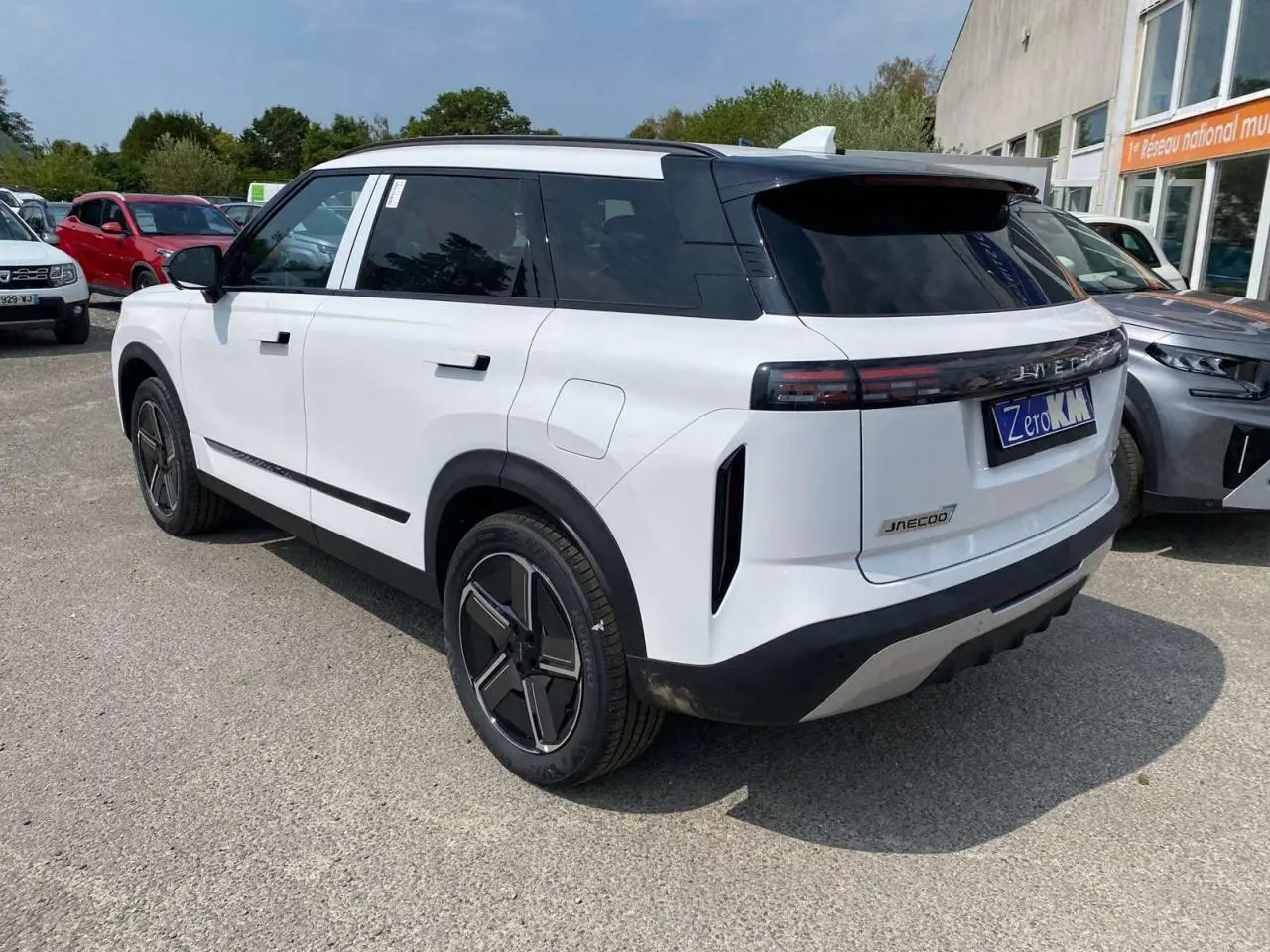 Vue 3/4 arrière droit du SUV JAECOO J7 blanc khaki avec jantes alliage noires et vitres arrière surteintées.