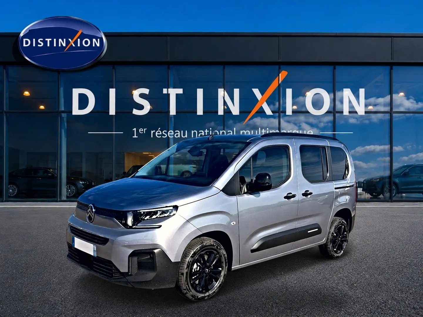 Citroën Berlingo Steel Grey vue 3/4 avant droit, avec jantes noires et barres de toit visibles.