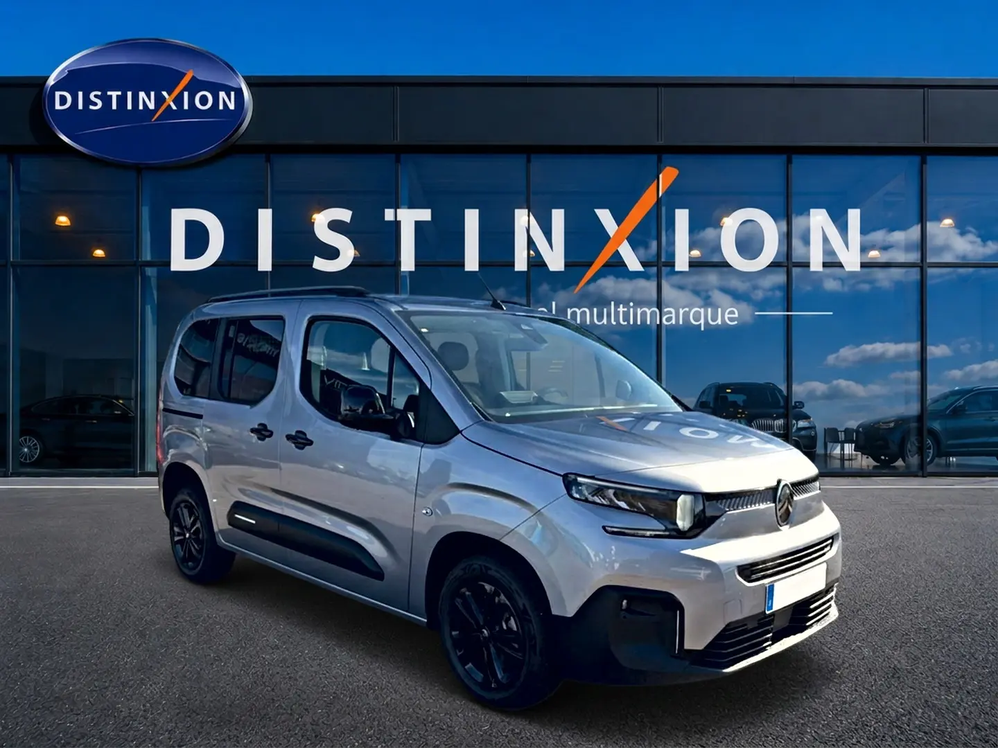 Citroën Berlingo N1 2026 gris acier en 3/4 avant droit, avec barres de toit et jantes noires.