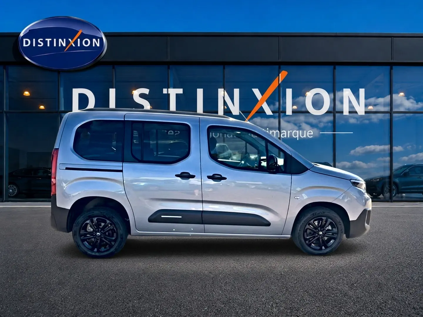 Profil droit d'un Citroën Berlingo 2026 gris acier avec barres de toit et jantes alliage noires.