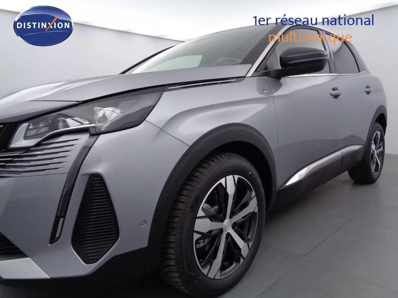 Gros plan sur la roue avant gauche et l'aile gris artense métallisé du Peugeot 3008 GT 2023 avec logo GT visible.
