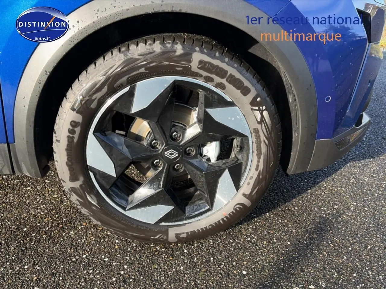 Gros plan sur la roue avant droite d’un Renault Captur 2025 Bleu Iron avec jante alu bicolore design.