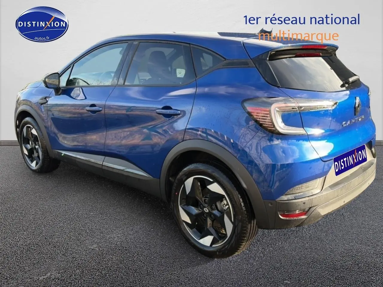 Renault Captur bleu iron vu en 3/4 arrière droit, avec jantes alliage et toit noir contrasté.