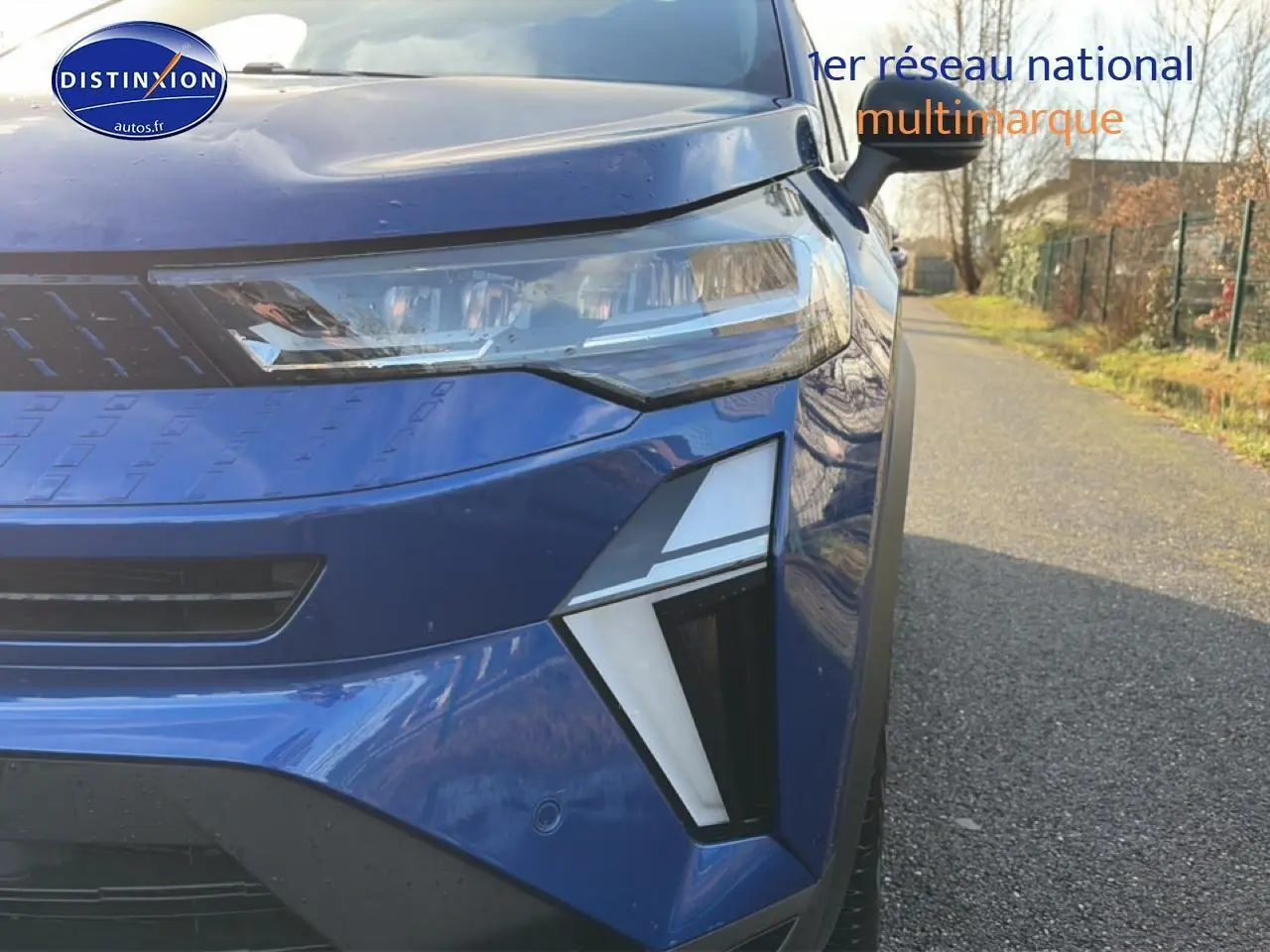 Gros plan sur l'avant droit du Renault Captur Bleu Iron 2025, mettant en valeur les phares LED et la calandre.