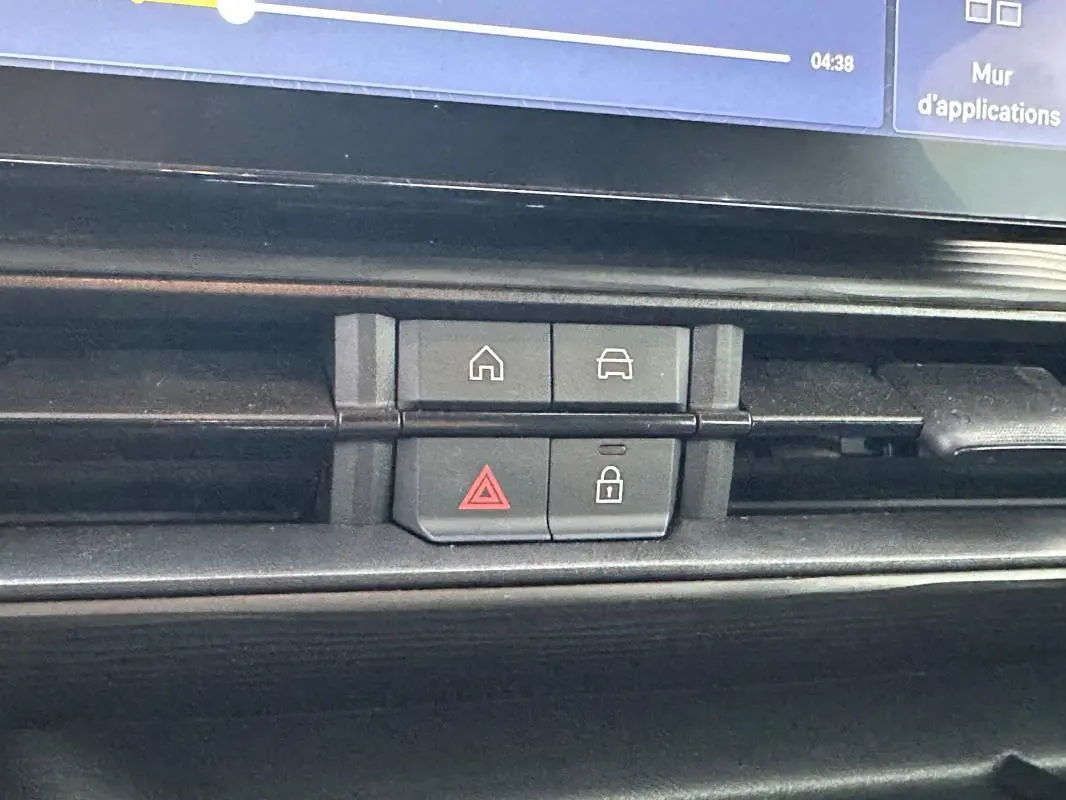 Boutons de commande du tableau de bord du Jeep Avenger noir, avec icônes maison, voiture, alerte et verrouillage.