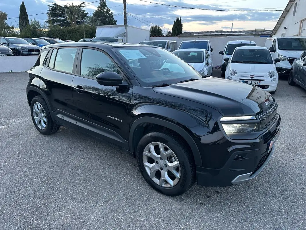 Jeep Avenger noir en vue 3/4 avant droit, avec jantes alliage 17 pouces et phares LED allumés.