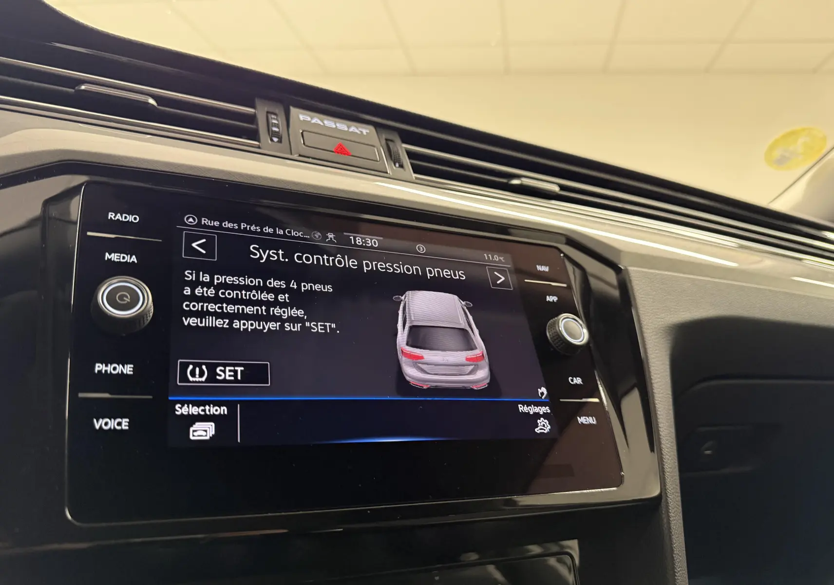 Vue rapprochée de l'écran tactile central de la Volkswagen Passat SW 2024 affichant le système de contrôle pression pneus.