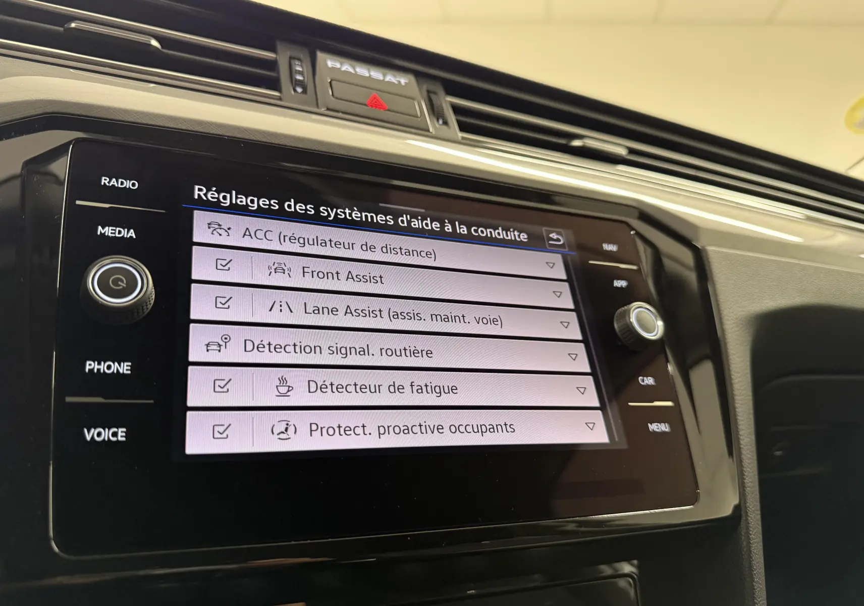 Écran tactile du système d’aide à la conduite dans une Volkswagen Passat SW 2024, affichant les réglages des assistances.
