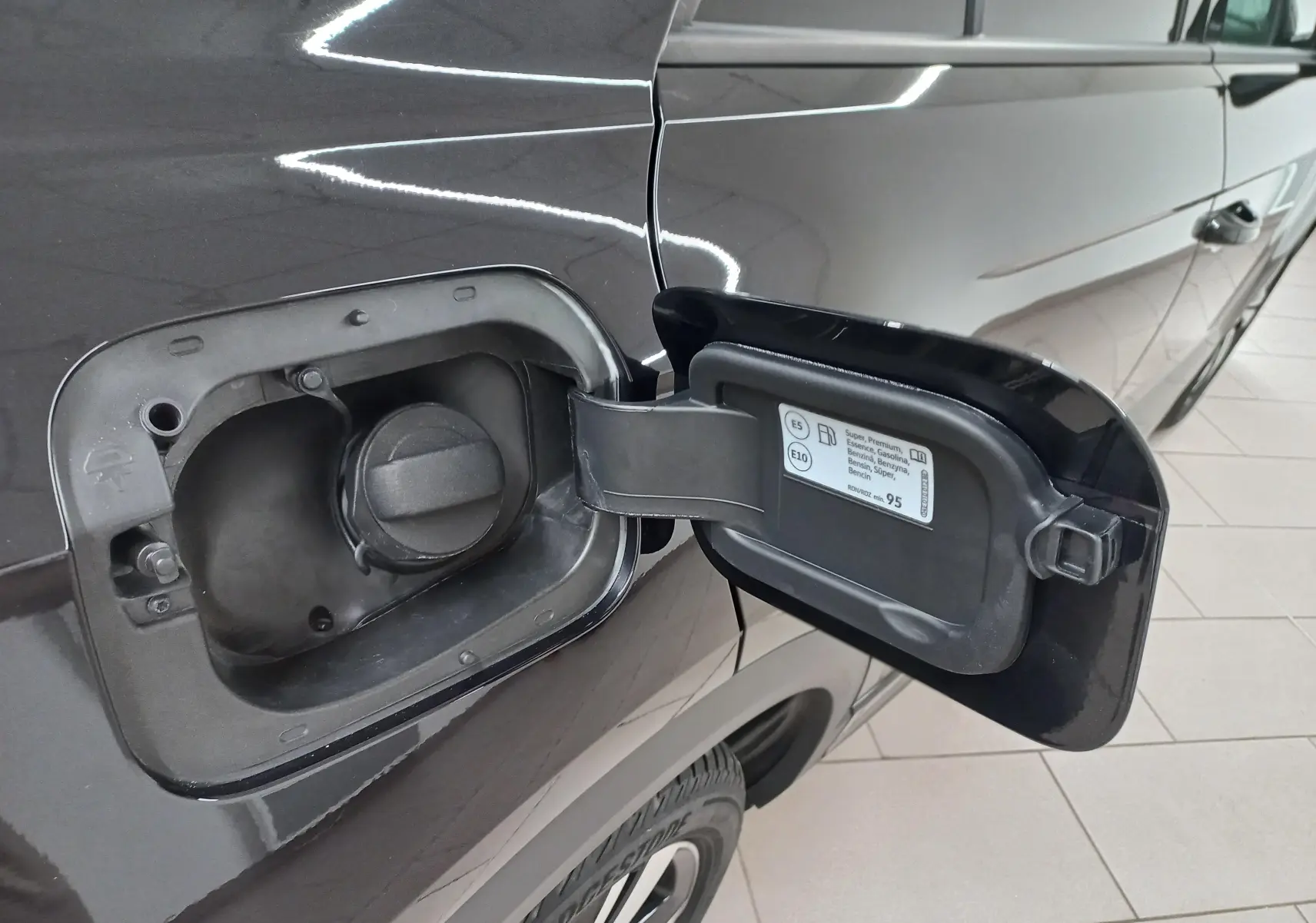 Vue rapprochée de la trappe à carburant ouverte côté gauche du Volkswagen T-Roc noir intense nacré 2025.