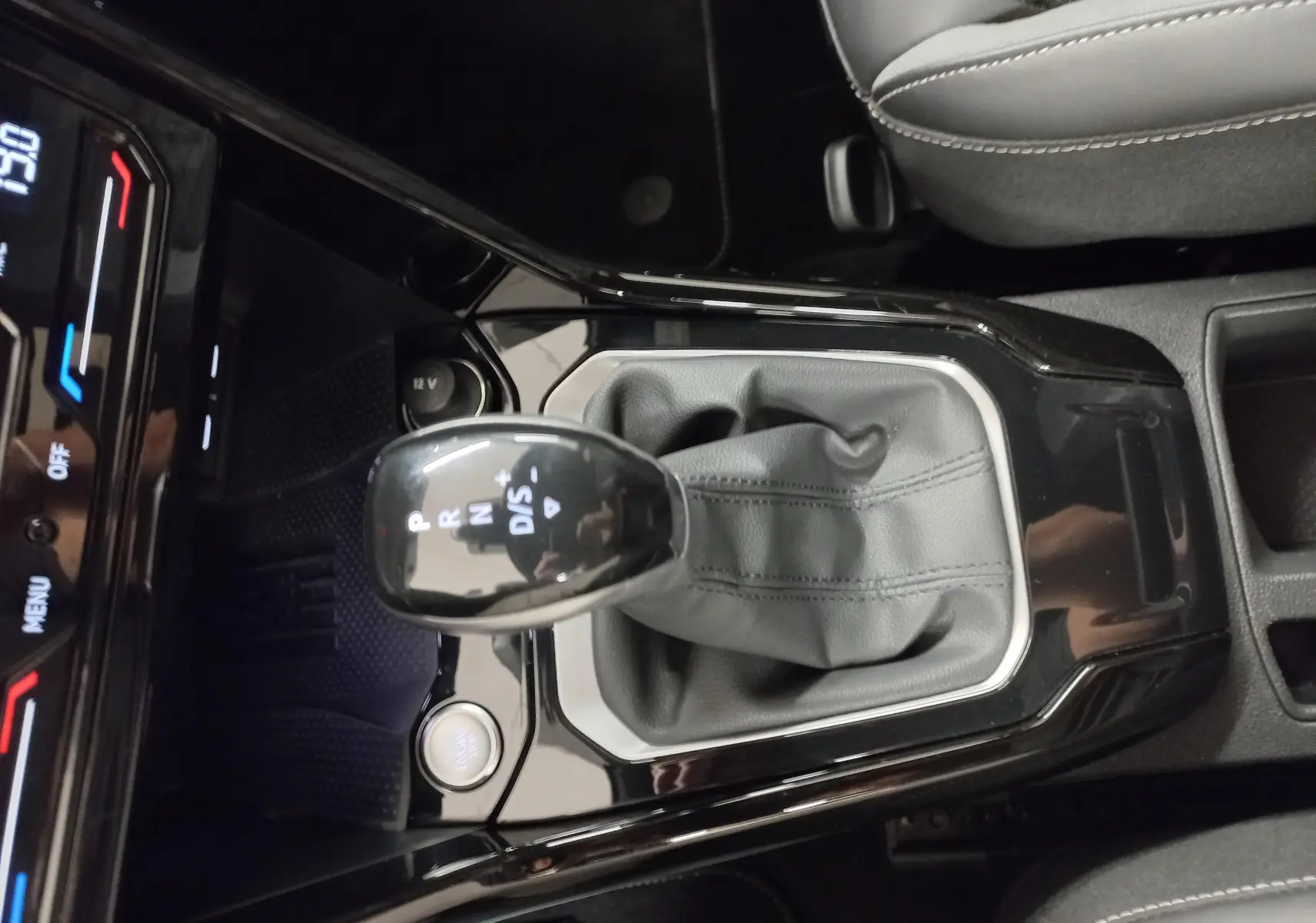 Gros plan sur la commande de boîte automatique DSG7 du Volkswagen T-Roc 1.5 TSI 150 R-Line, intérieur noir.