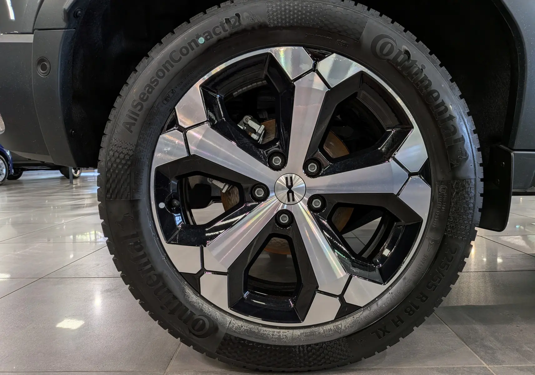 Gros plan sur la jante biton noire et argentée du Dacia Duster Hybrid-G 150 CH 4x4 gris schiste, vue côté gauche.