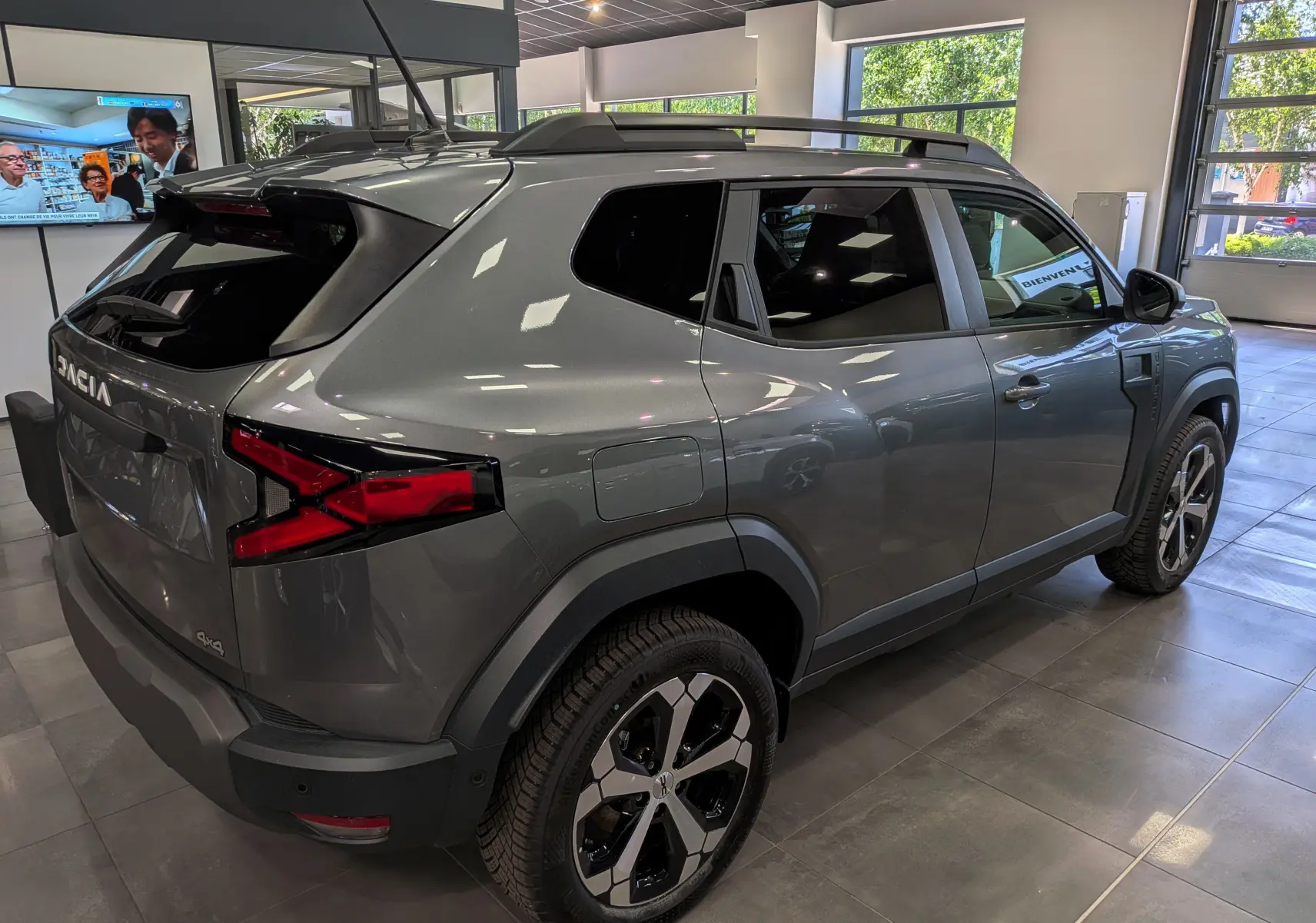 Vue 3/4 arrière droite du Dacia Duster Hybrid-G gris schiste, avec jantes biton et feux arrière distinctifs en X.