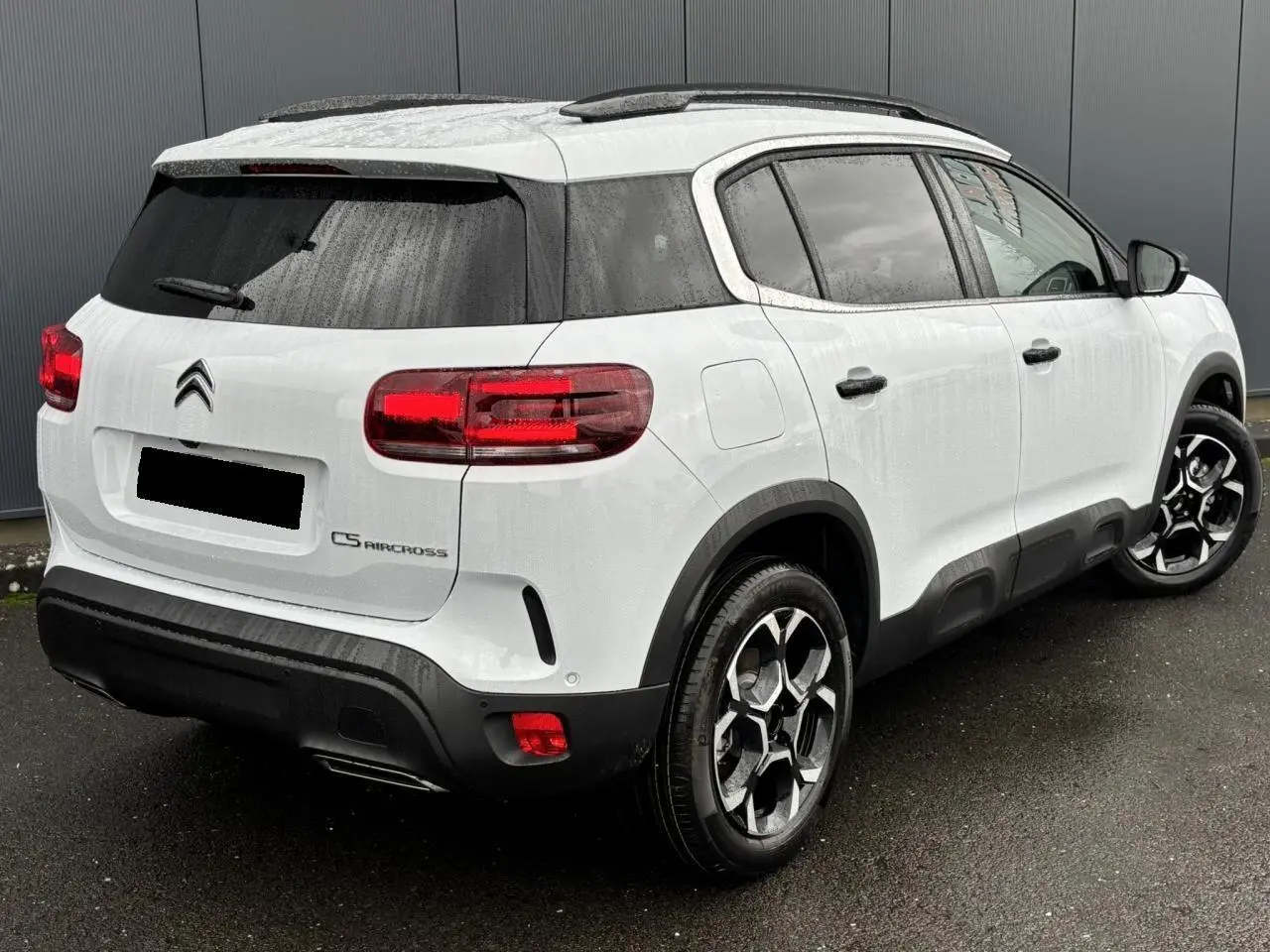 Vue 3/4 arrière droite du Citroën C5 Aircross blanc Okénite avec jantes alliage bi-ton et vitres surteintées.