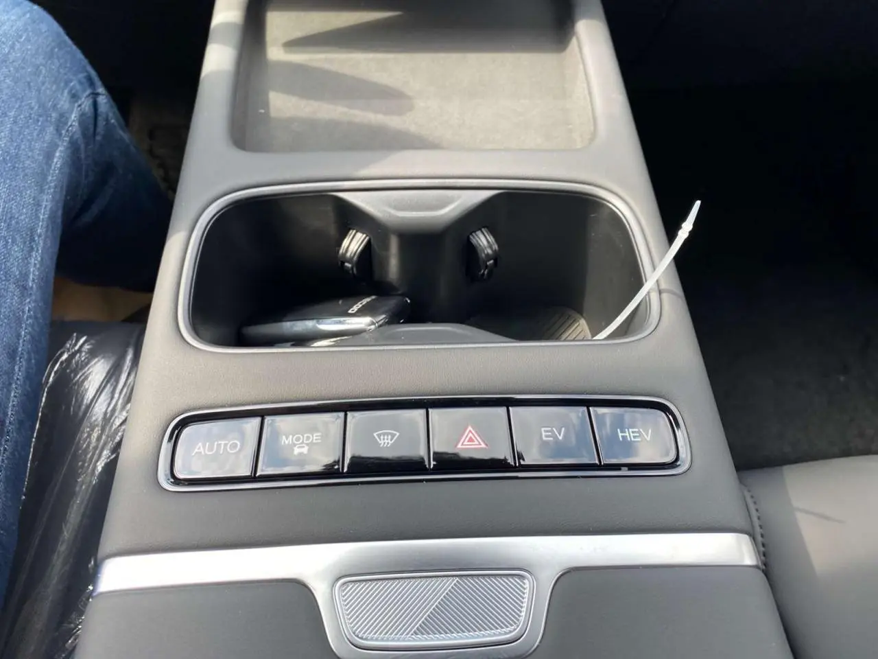 Gros plan sur la console centrale noire du JAECOO J7 argent Moonlight, avec rangements et boutons de modes de conduite.