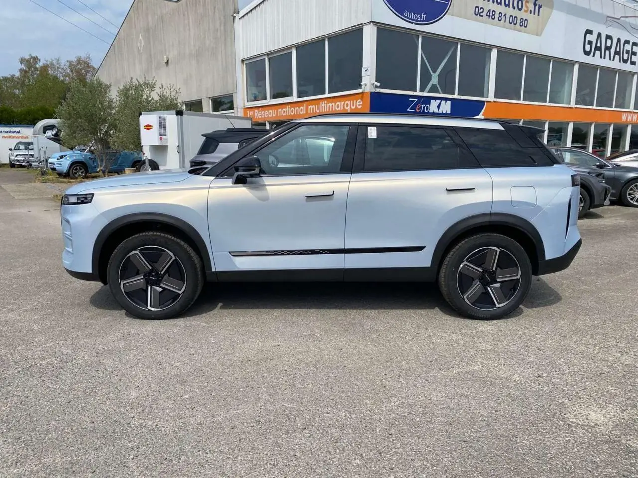 Vue de profil droit du SUV JAECOO J7 2026 en argent Moonlight, avec toit noir et jantes modernes bicolores.