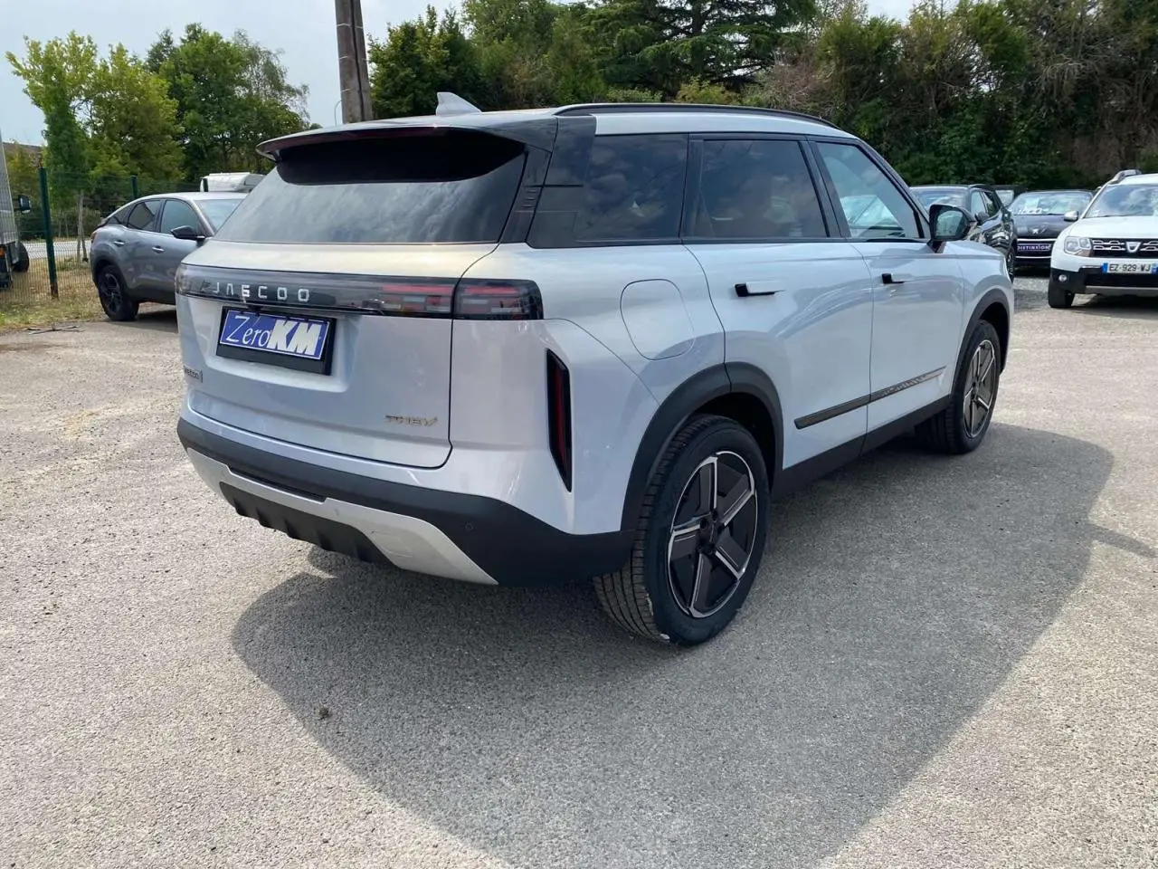 Vue 3/4 arrière droite du SUV JAECOO J7 argent Moonlight avec toit noir et vitres arrière surteintées.