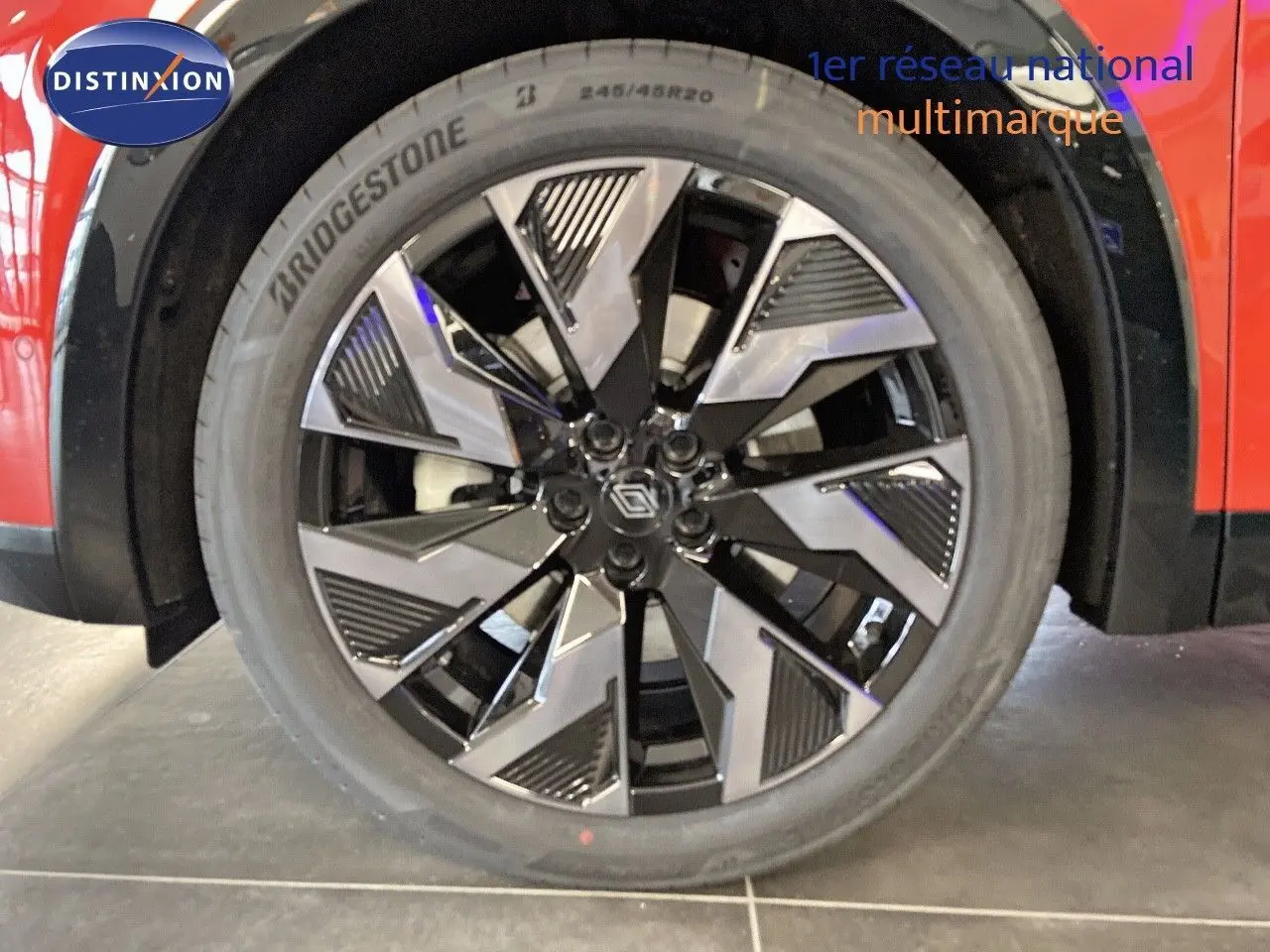 Gros plan sur la jante avant droite noire et argentée du Renault Rafale rouge flamme métal 2024.