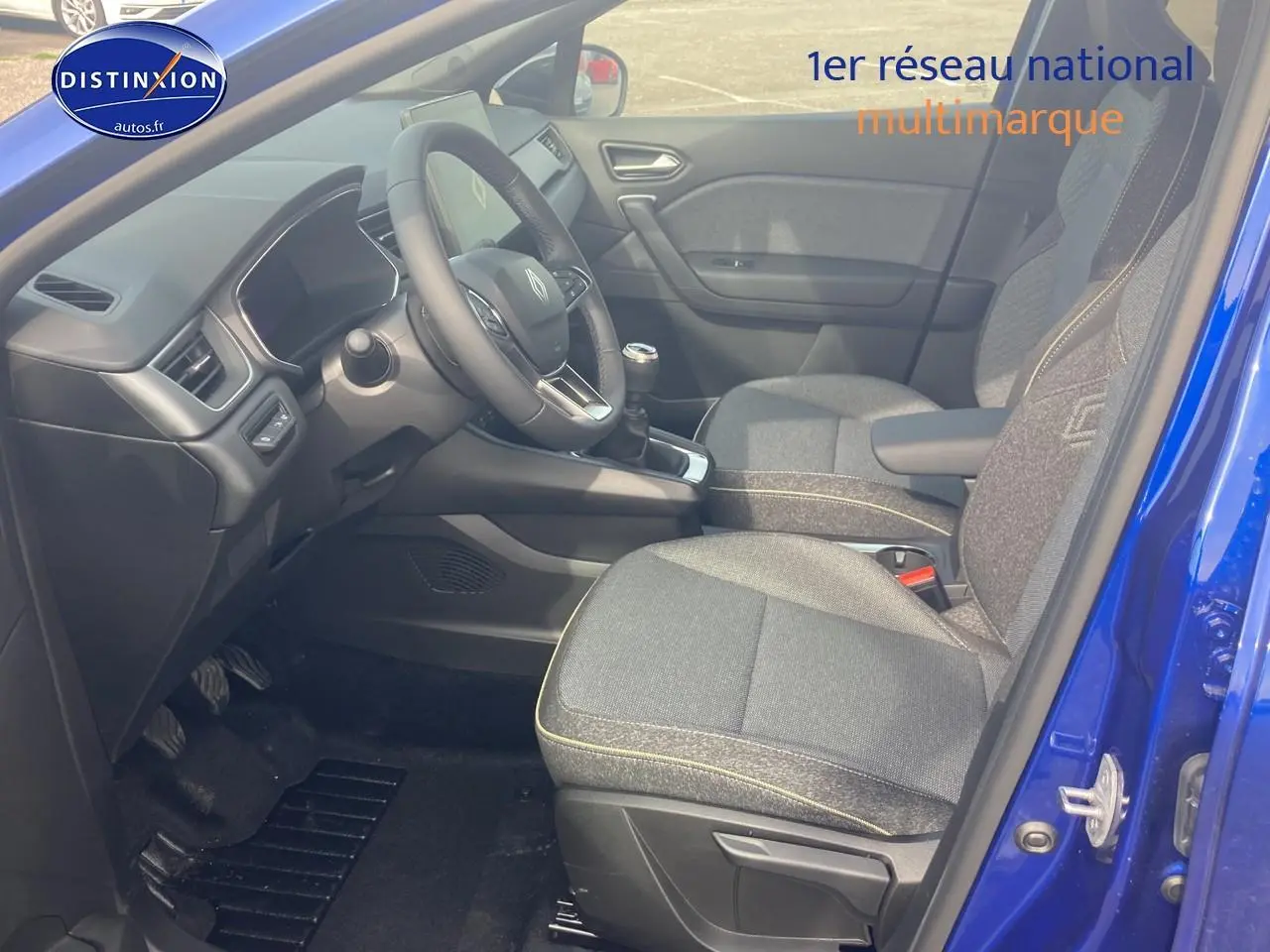 Vue intérieure côté conducteur du Renault Captur Bleu Iron 2025 avec sièges gris et volant multifonction.