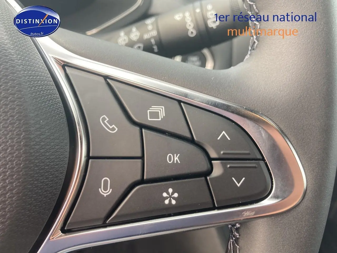 Gros plan sur les commandes multifonctions noires du volant du Renault Captur Bleu Iron, version 2025.