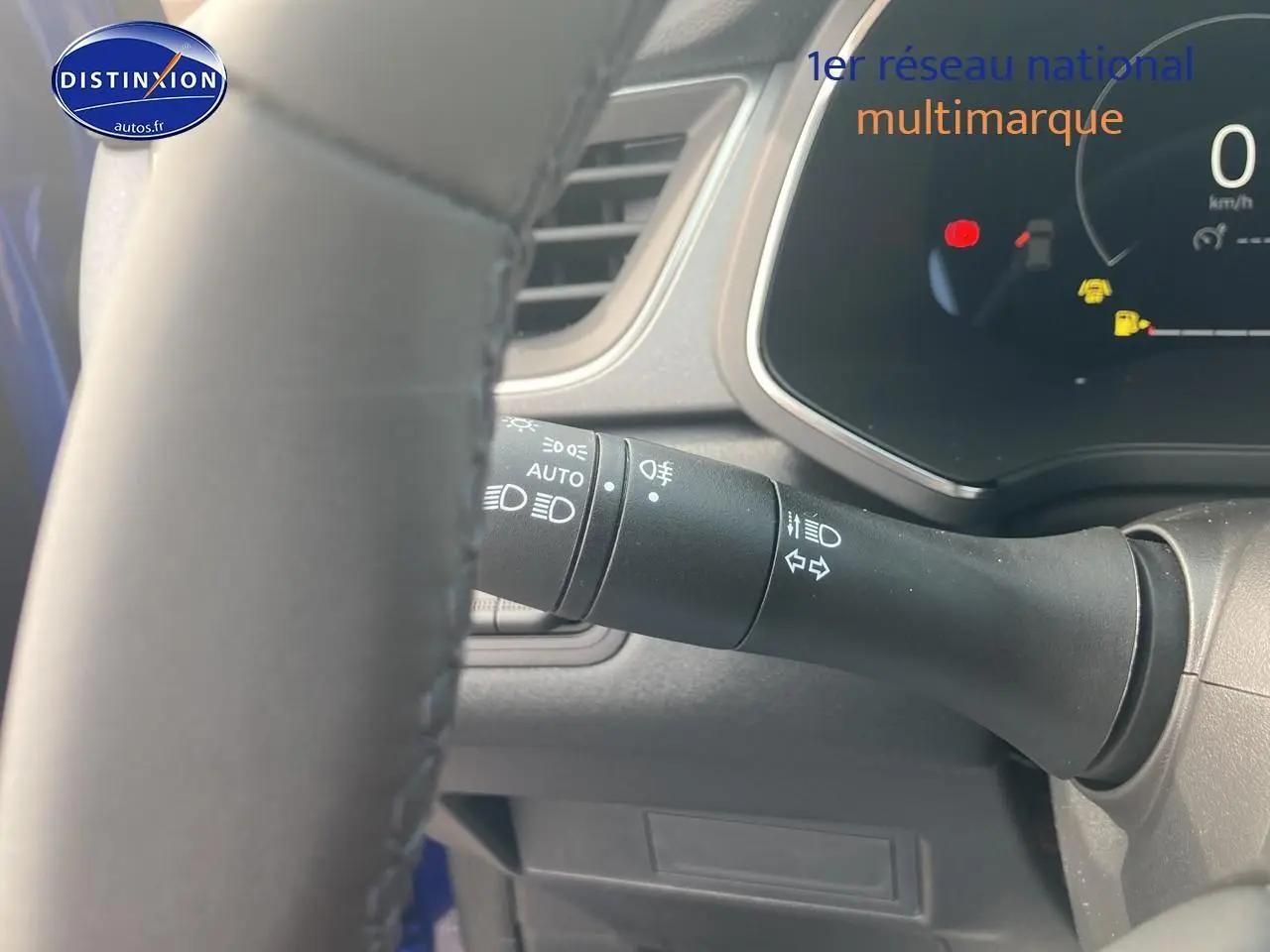 Détail du commodo d’éclairage côté gauche du volant d’un Renault Captur Bleu Iron 2025.