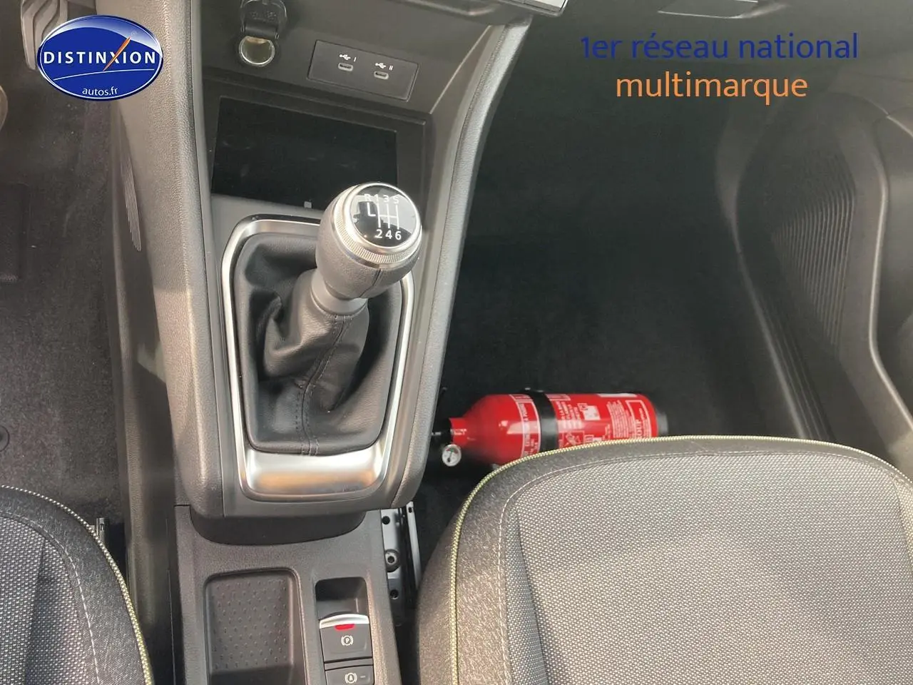 Vue intérieure centrée sur la console centrale avec levier de vitesse manuel et siège avant gris du Renault Captur Bleu Iron.