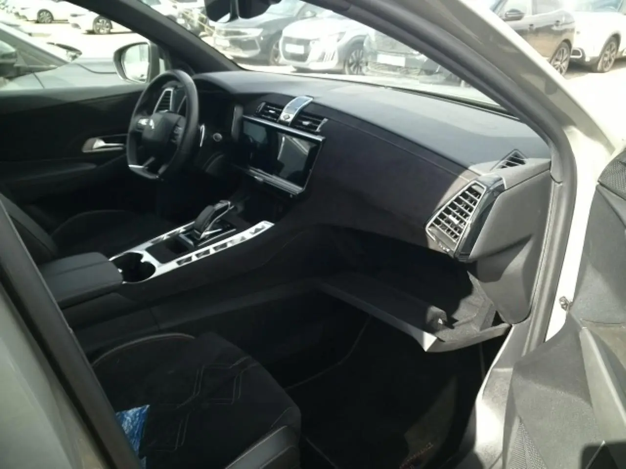 Vue intérieure côté passager du DS7 2024 gris laqué, mettant en valeur le tableau de bord et la console centrale en Alcantara noir profond.