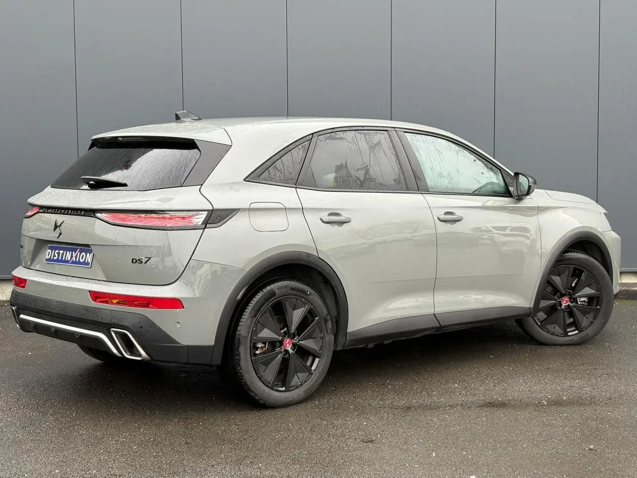 Vue 3/4 arrière droite du DS7 1.6 E-Tense 225 gris laqué avec jantes noires et feux arrière LED fins.