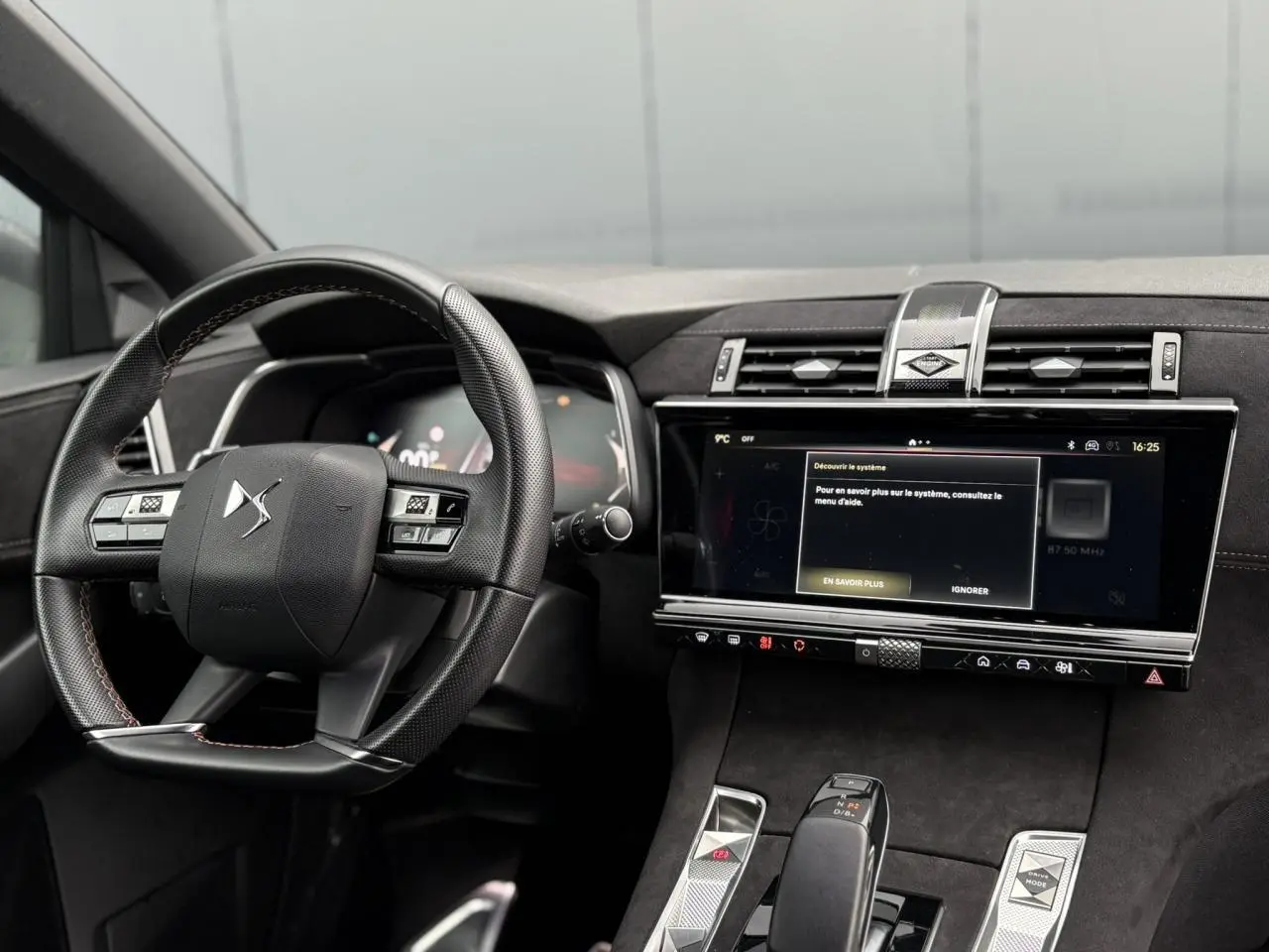 Vue intérieure du tableau de bord et volant DS7 1.6 E-Tense 2024 en Alcantara noir avec écran tactile large et finitions argentées.