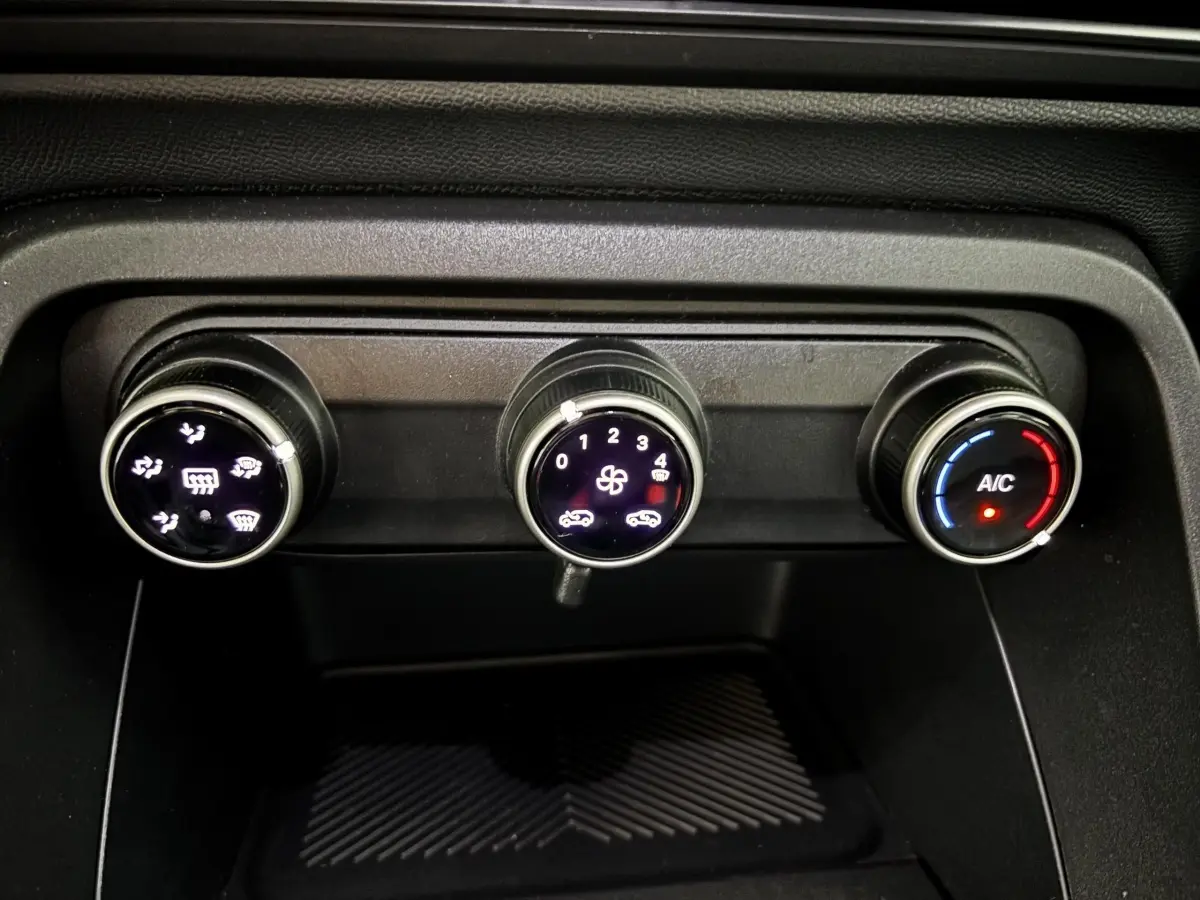 Gros plan sur les commandes de climatisation de la Citroën C3 100 BVM PLUS 2025, avec réglages rotatifs éclairés.