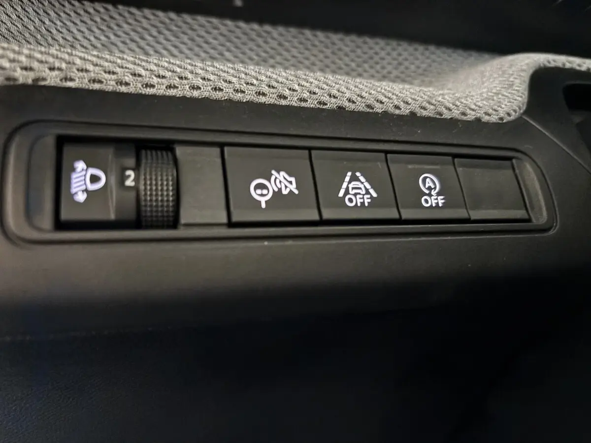 Gros plan sur les boutons de commande du tableau de bord de la Citroën C3 100 BVM PLUS, intérieur noir.