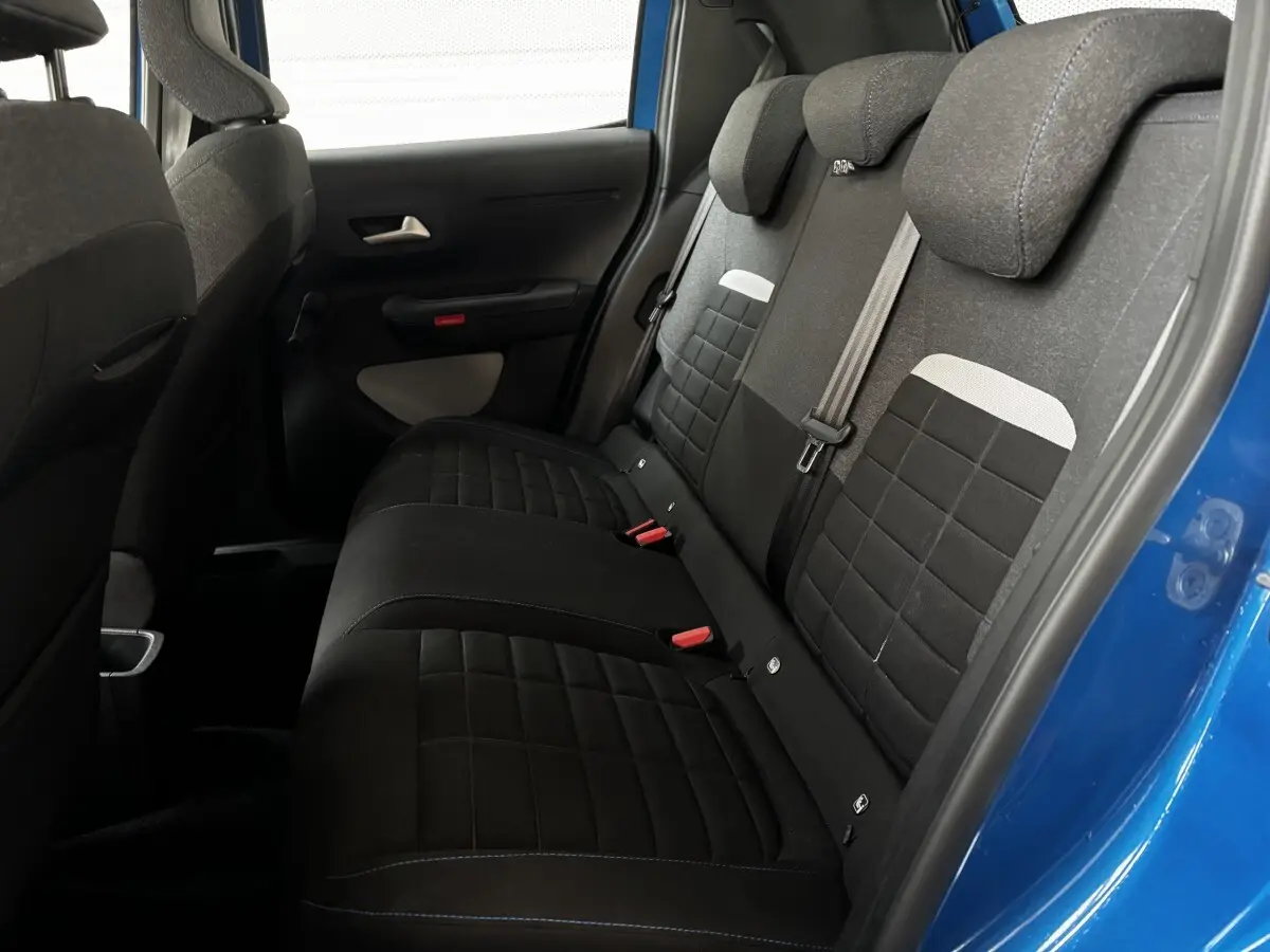 Vue intérieure côté droit sur la banquette arrière noire de la Citroën C3 100 BVM PLUS bleu 2025 avec appuie-têtes intégrés.
