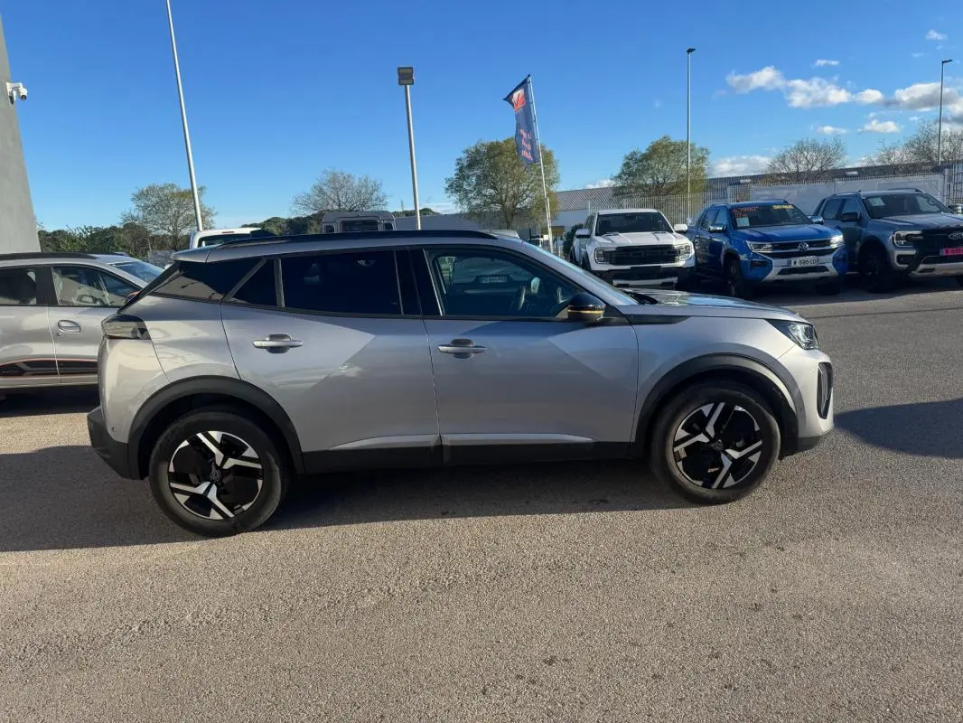Peugeot 2008 Hybrid gris vue de profil côté gauche, avec jantes alliage 17 pouces et barres de toit noires.