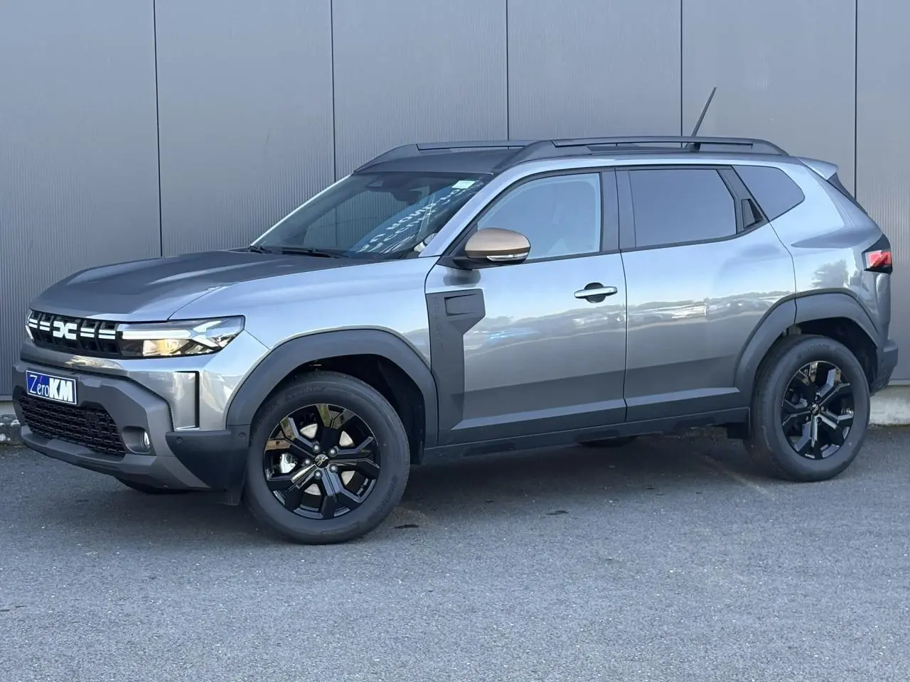 SUV Dacia Duster ECO-G 120 Auto Extrême gris schiste, vue de profil côté gauche avec jantes noires et barres de toit.