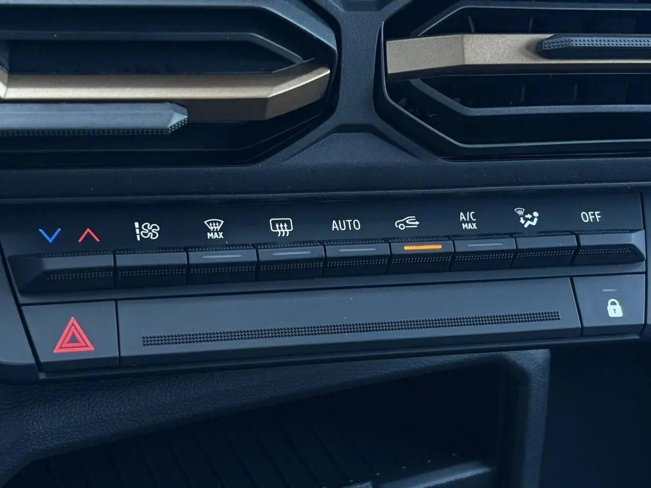 Gros plan sur la console centrale du Dacia Duster 2026 gris schiste, montrant les commandes de climatisation automatique.