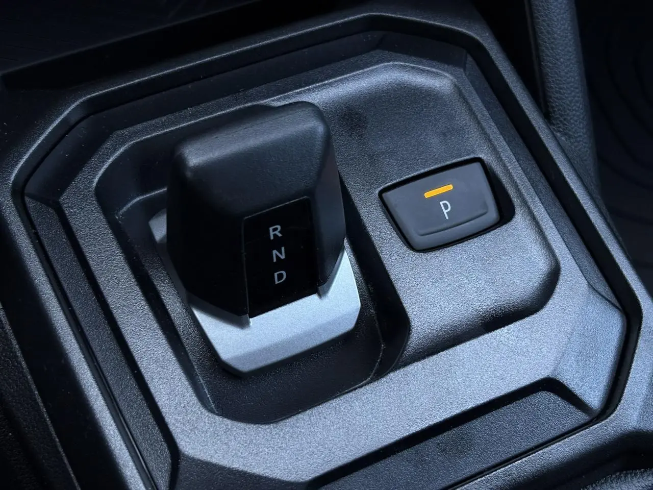 Gros plan sur la commande de boîte automatique et bouton parking du Dacia Duster gris Schiste 2026 intérieur.