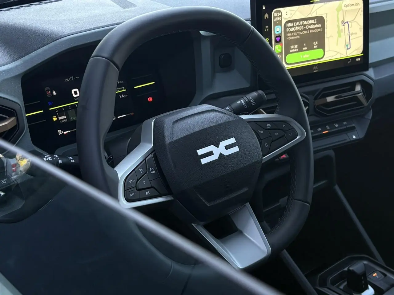Vue rapprochée de l’intérieur du Dacia Duster 2026, volant multifonctions et écran tactile central avec navigation visible.