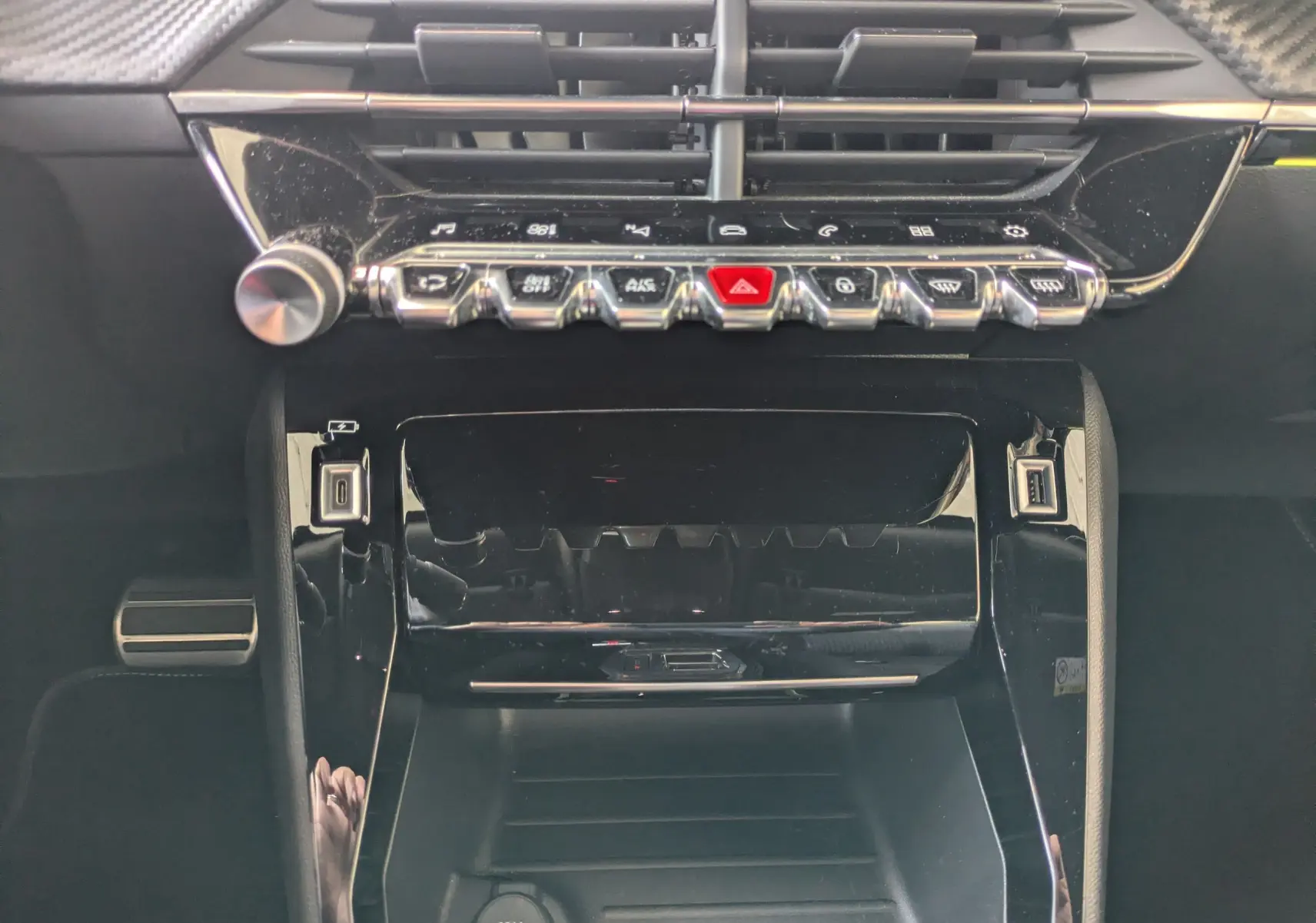 Vue rapprochée de la console centrale noire brillante du Peugeot 2008 GT 2022 avec commandes tactiles et ports USB visibles.