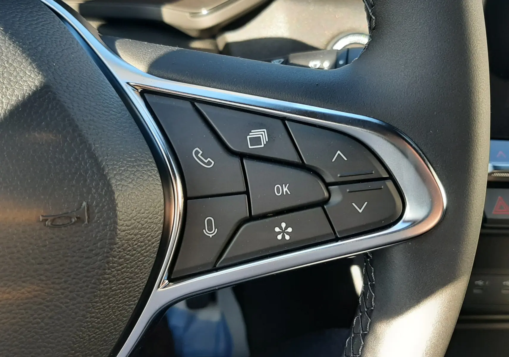 Gros plan sur les commandes au volant du Renault Captur bleu Iron 2025, boutons multifonctions avec finition chromée.