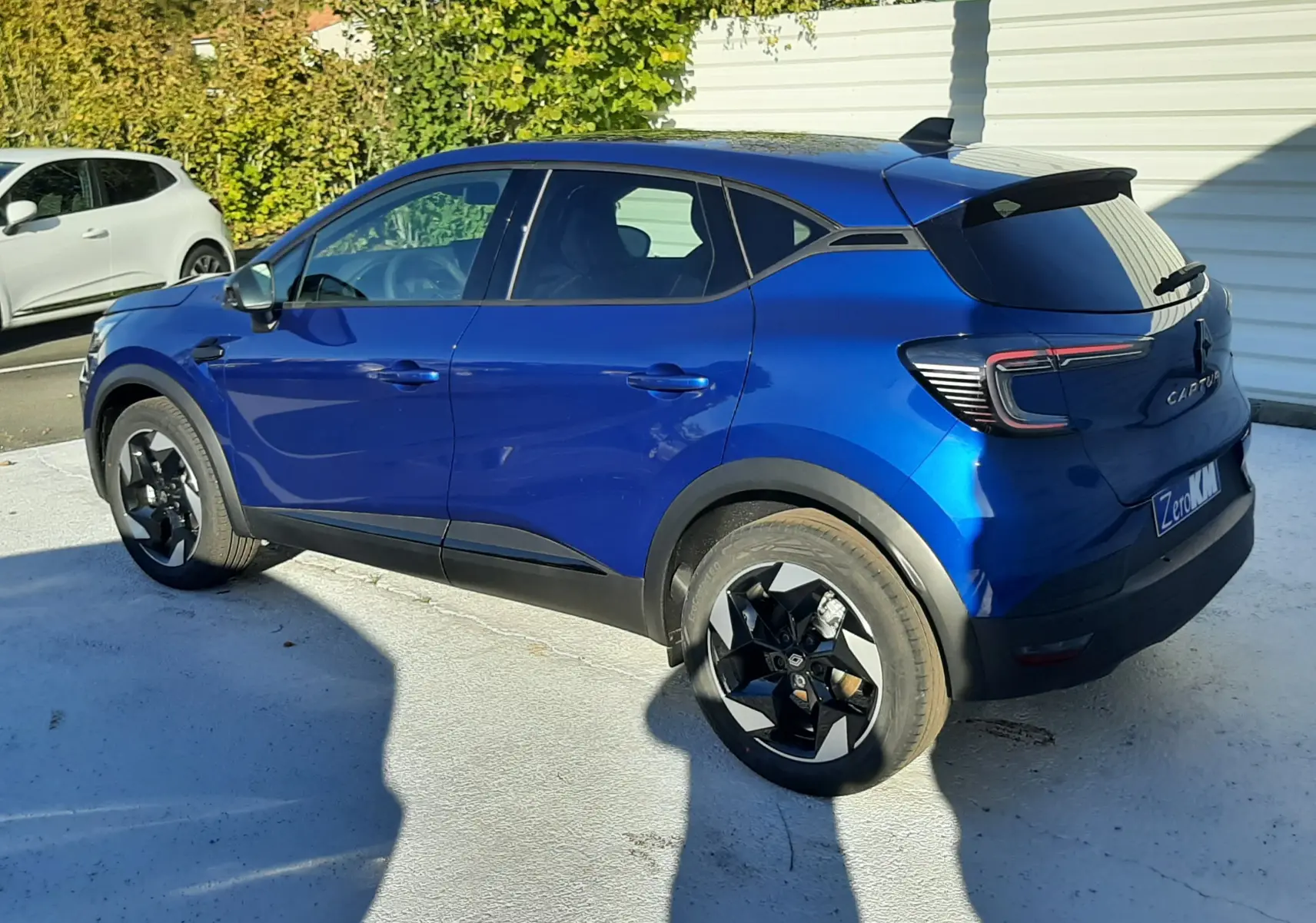 Renault Captur II Ph.2 TCE 90CH TECHNO bleu Iron vu de profil côté droit, avec jantes noires et toit noir contrasté.