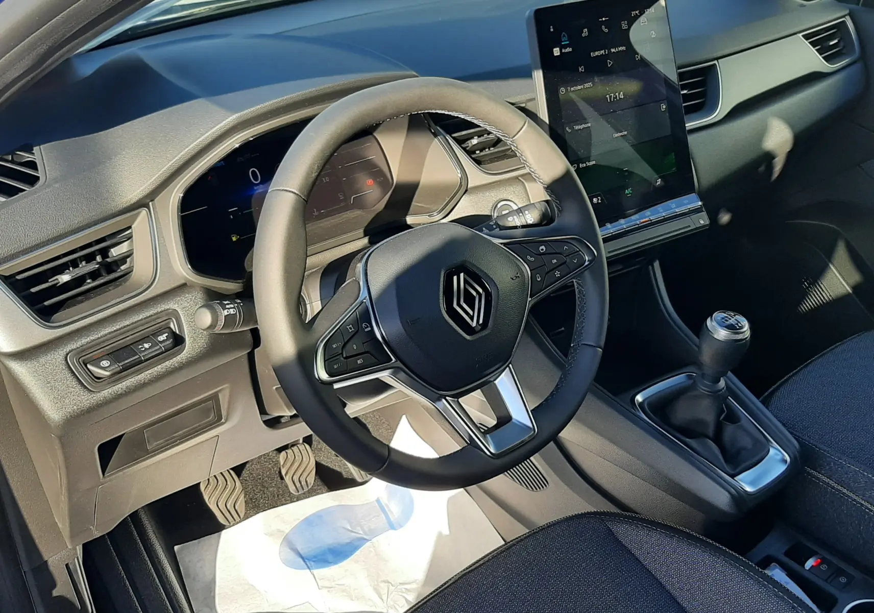 Intérieur du Renault Captur II Ph.2, vue côté conducteur sur le volant multifonction, tableau de bord numérique et levier de vitesses manuel.