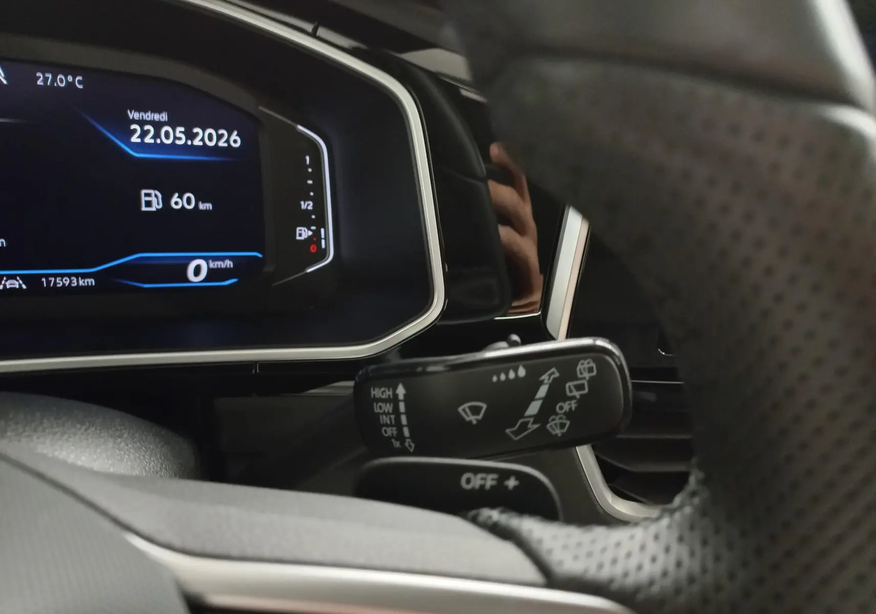 Vue rapprochée du tableau de bord numérique et du commodo d’essuie-glace du Volkswagen T-Roc noir intense 2025.