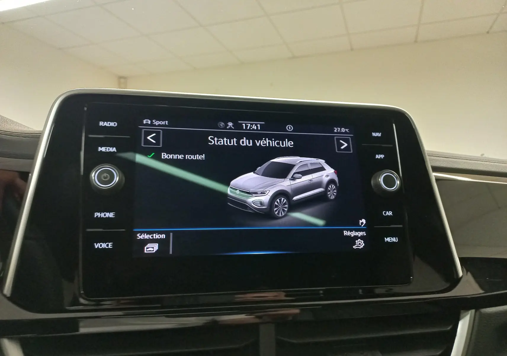 Écran tactile intérieur affichant le statut du véhicule Volkswagen T-Roc en vue 3/4 avant grise.
