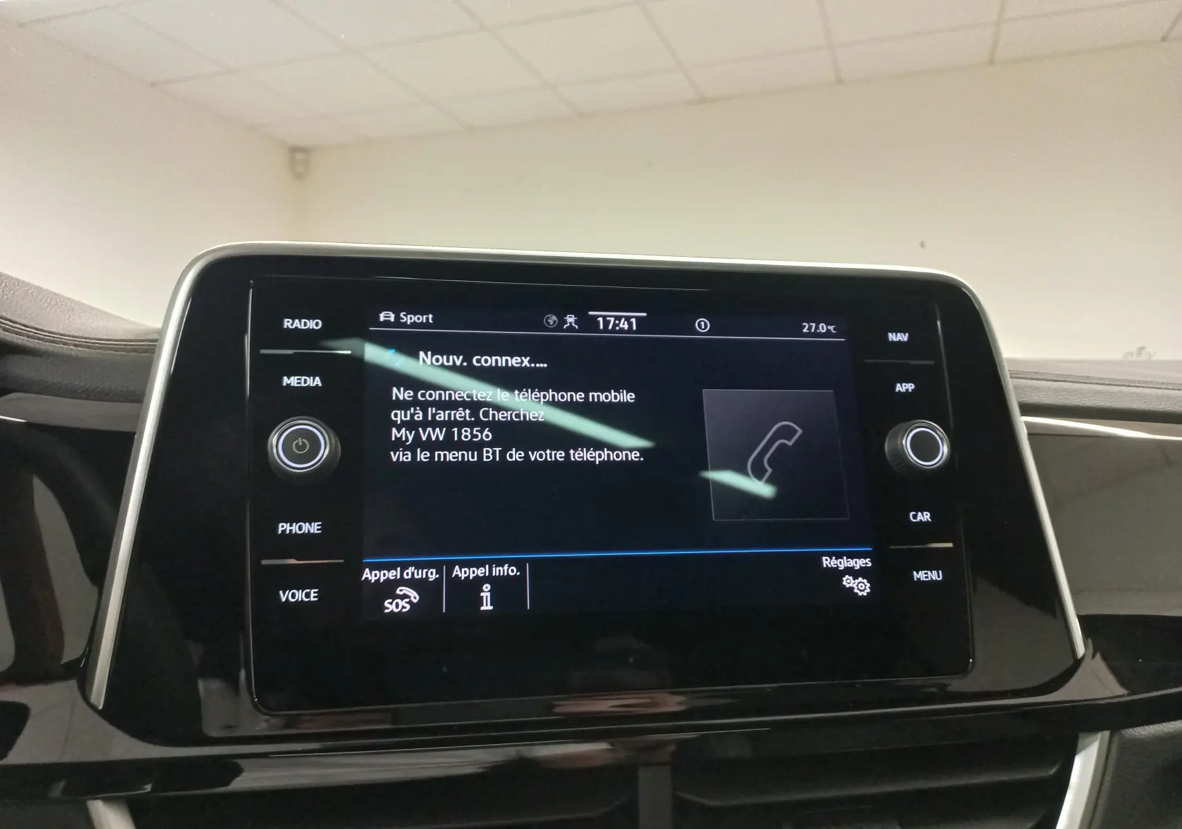 Écran tactile central du Volkswagen T-Roc 2025 affichant les options de connexion téléphone, intérieur noir brillant.