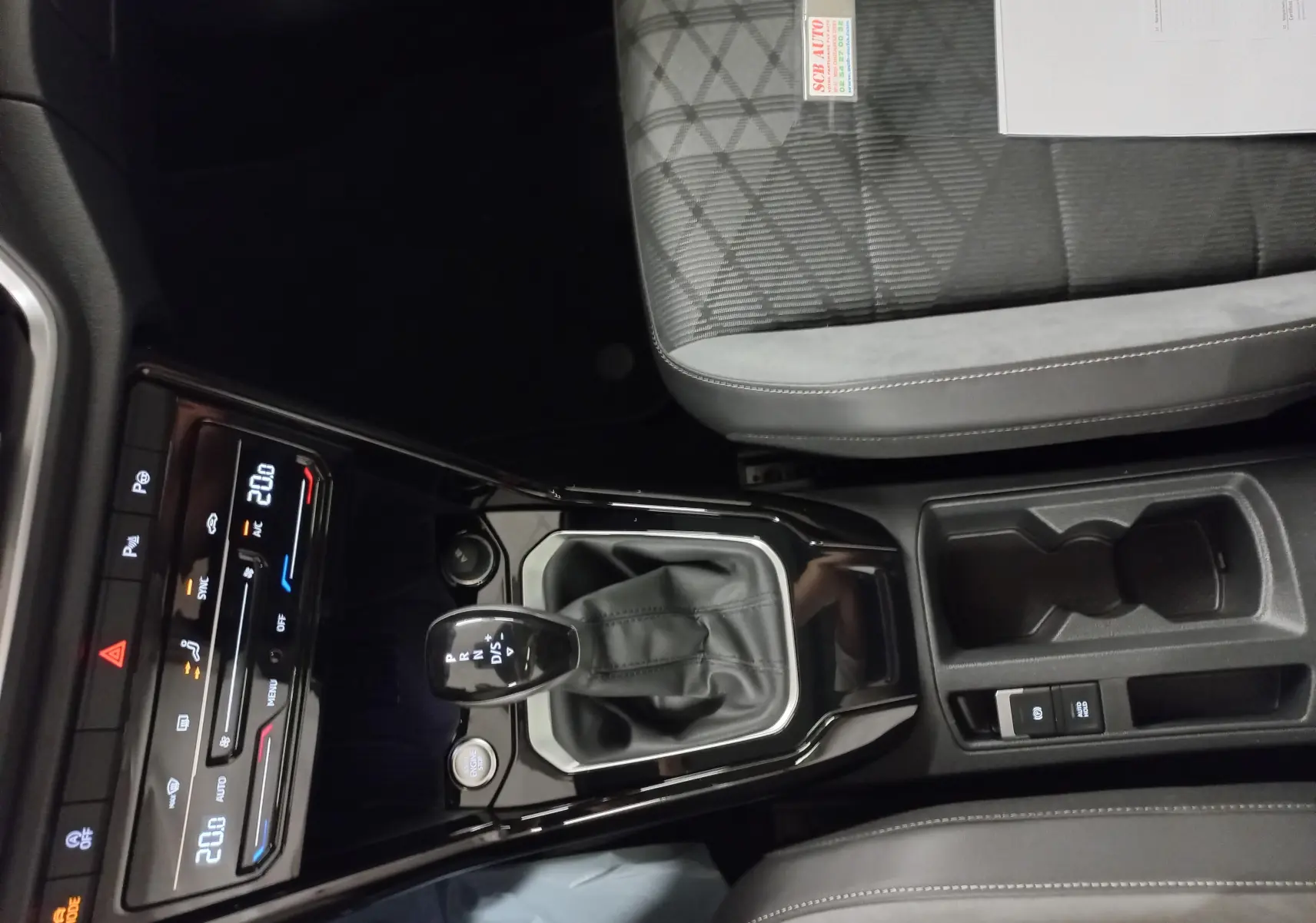 Vue intérieure centrée sur la console centrale et levier de vitesse du Volkswagen T-Roc noir intense 2025.