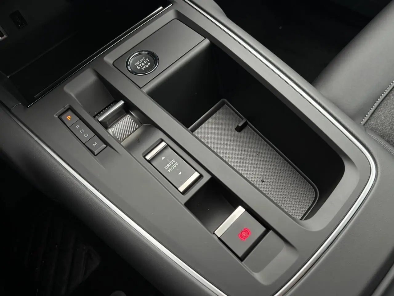 Vue rapprochée de la console centrale noire du Citroën C5 Aircross 2025 avec bouton start/stop et frein de stationnement électrique.